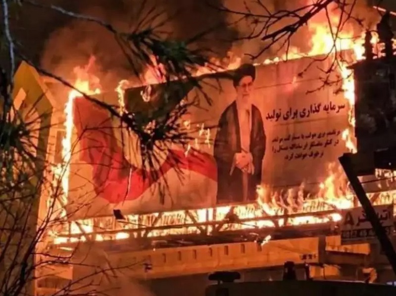 未标注具体时间的图片显示，愤怒的伊朗人民烧毁街道上悬挂的哈梅内伊画像
